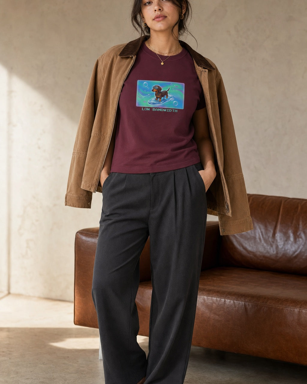 O's Tees Low Bandwidth Dachshund Frutiger Aero Dogs graphic tee lifestyle image — Maroon shirt, female shot 02, charcoal trouser camel