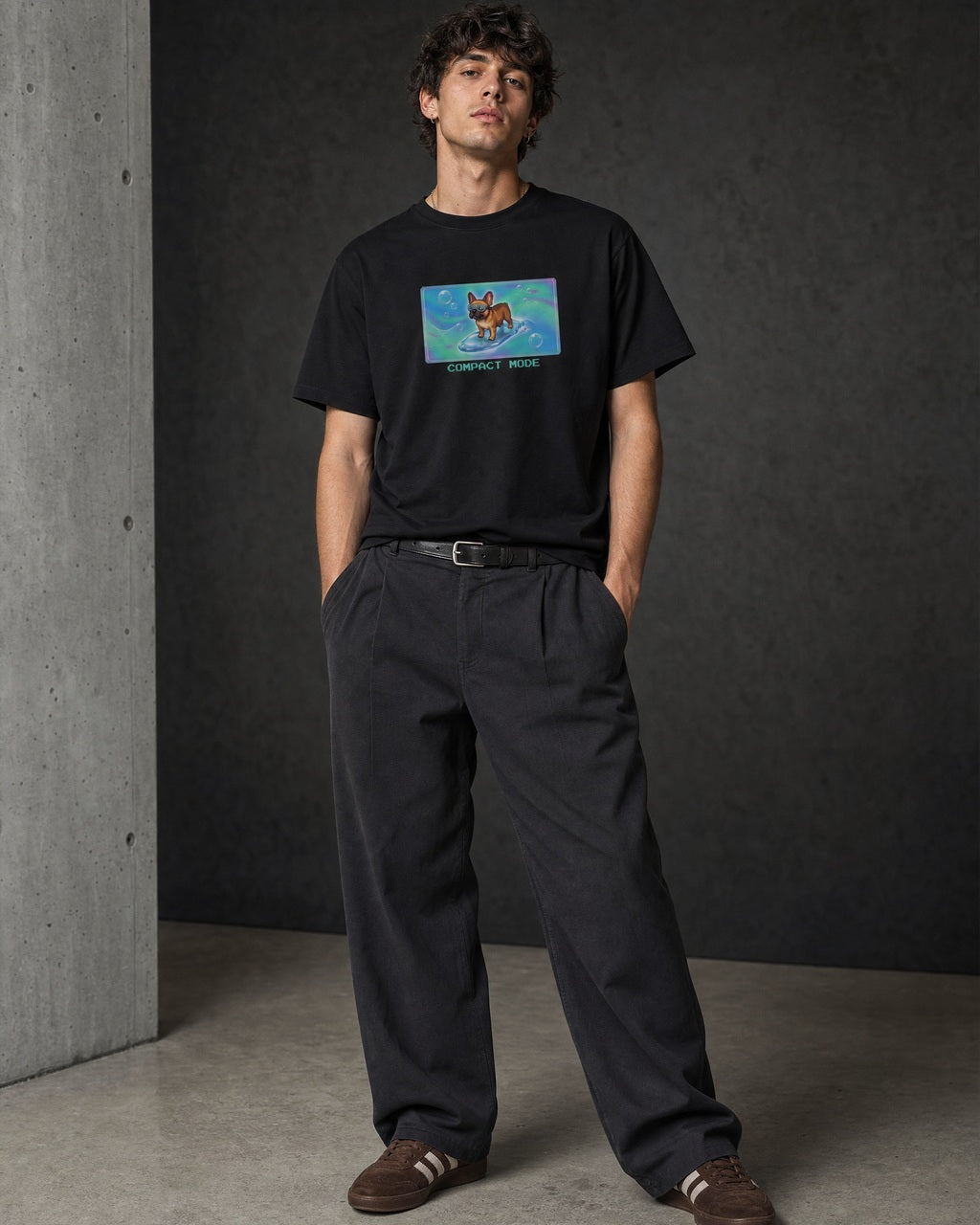 O's Tees Compact Mode French Bulldog Frutiger Aero Dogs graphic tee lifestyle image — Black shirt, male shot 01, charcoal pleated trouser