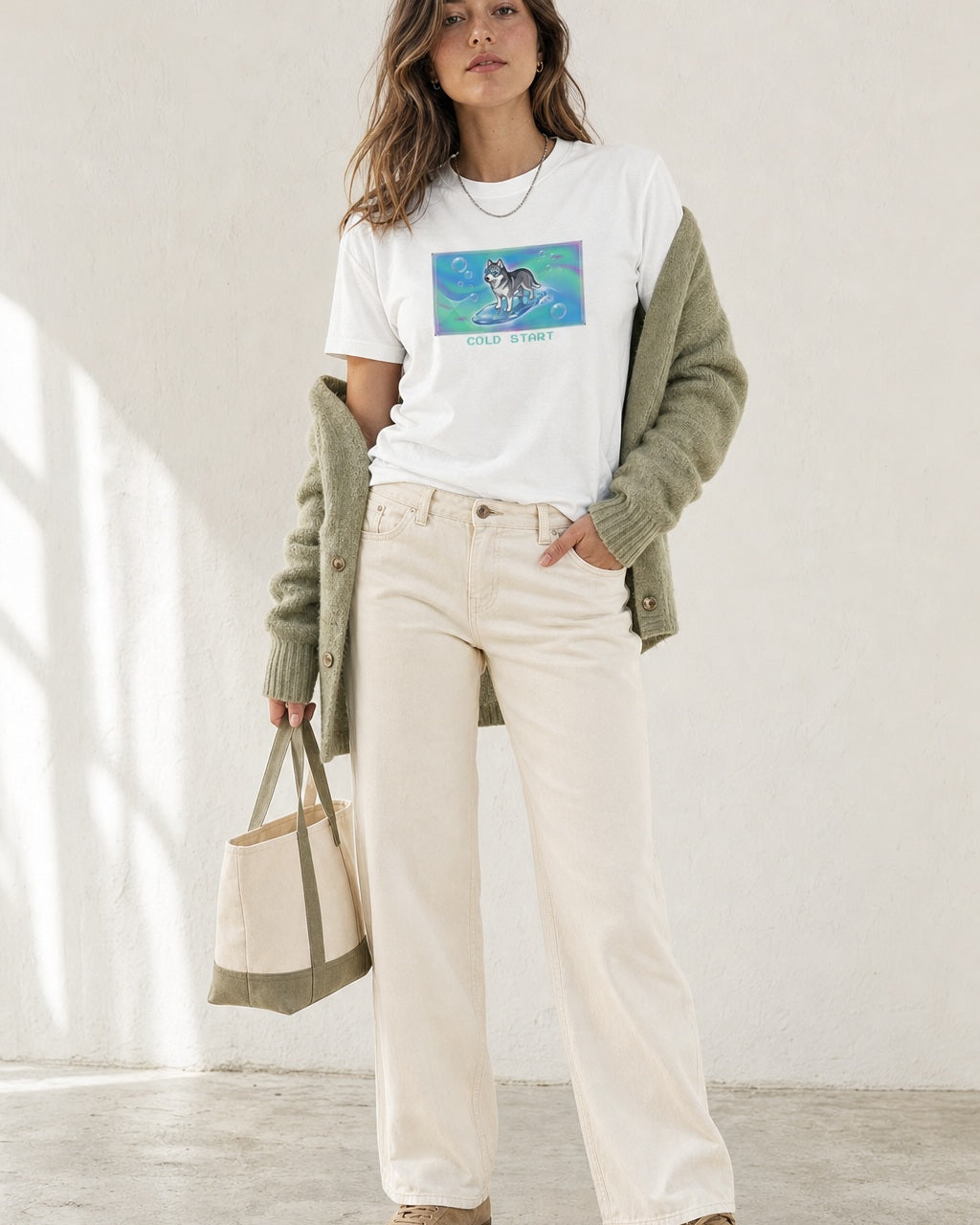 O's Tees Cold Start Husky Frutiger Aero Dogs graphic tee lifestyle image — White shirt, female shot 02, sage cardigan cream denim